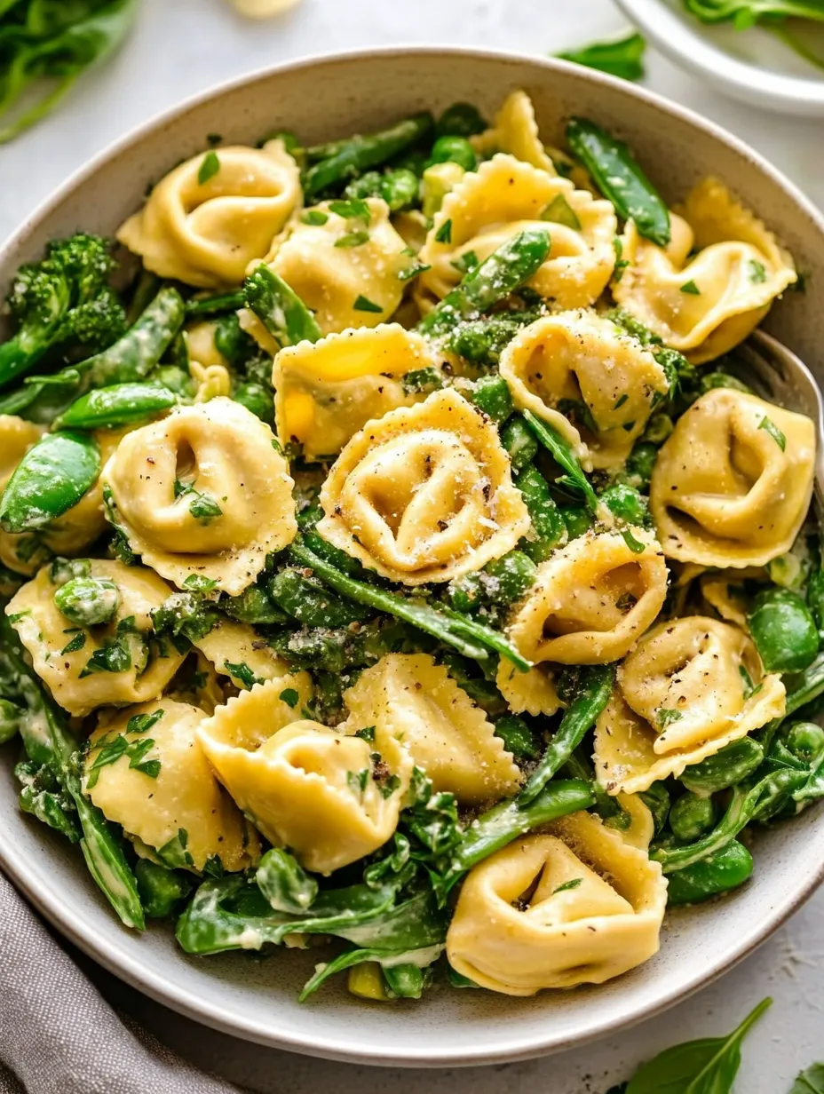 Eine Schüssel Pasta mit grünem Gemüse und Käse.