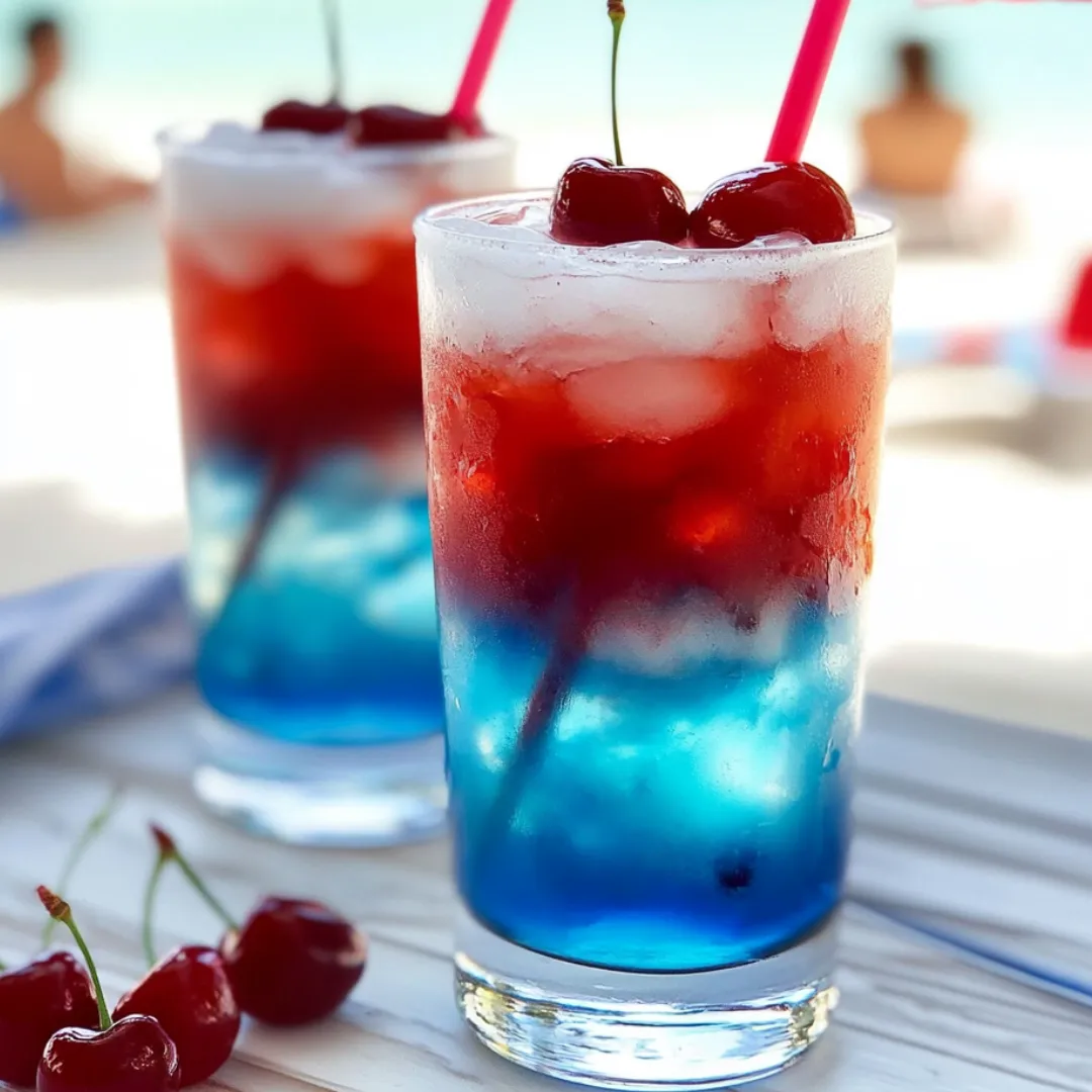 Zwei Gläser mit Kirsch-Limonade und Kirschen daneben.