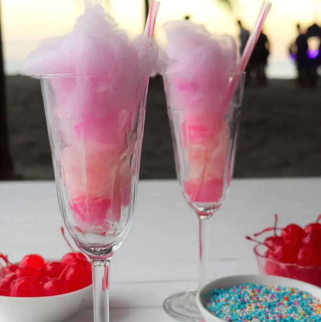 Zwei Gläser mit fluffiger pinker Zuckerwatte gefüllt.