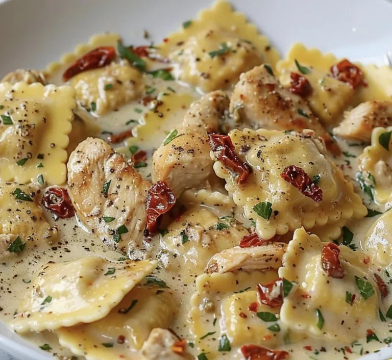 Ein Teller Pasta mit Huhn und roten Paprika.