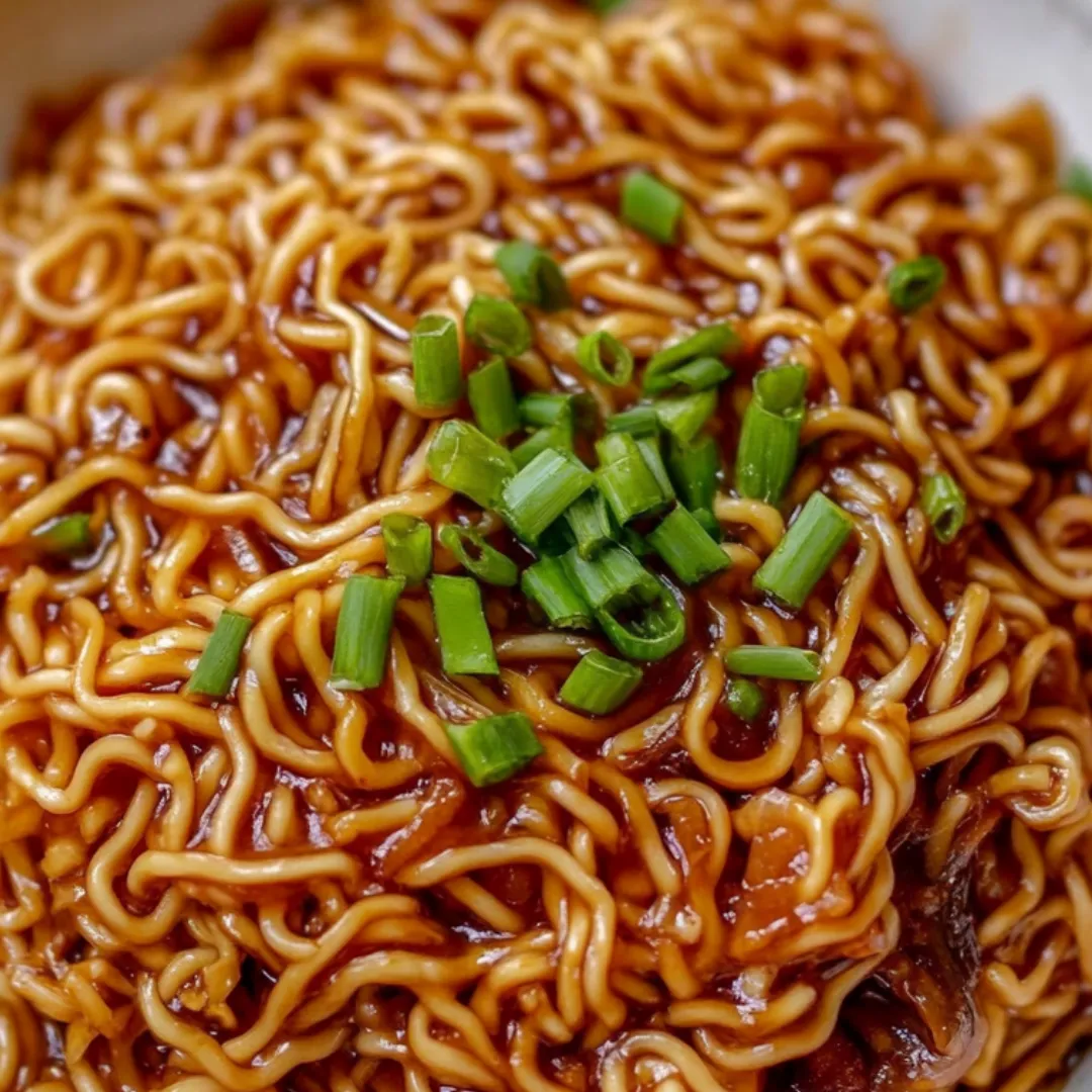 Eine Schüssel Nudeln mit Frühlingszwiebeln obendrauf.