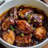 Eine Schale mit Huhn und Sauce.