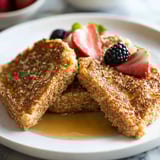 Ein Teller mit Toast, Erdbeeren und Blaubeeren.