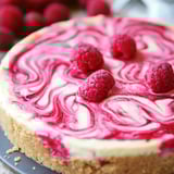 Ein Kuchenstück mit Himbeeren oben drauf.