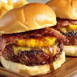 Zwei Hamburger mit Bacon, Ananas und Soße voll belegt.