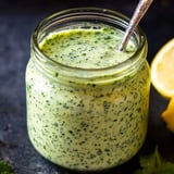 Ein Glas mit grüner Sauce und Löffel drin.