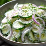 Eine Schüssel mit Gurkenscheiben und Zwiebeln.