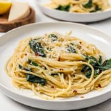 Spaghetti mit viel Spinat und zartem Käse auf dem Teller.