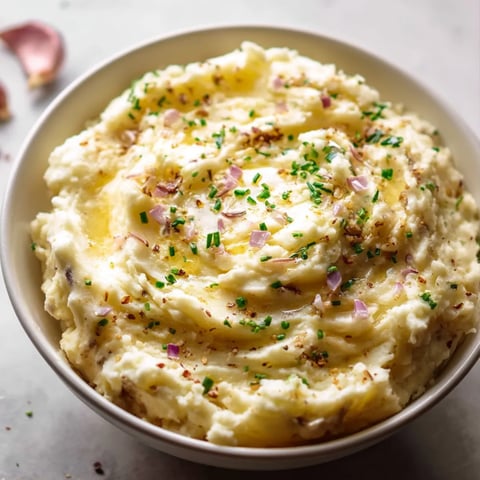 Eine Schüssel Kartoffelpüree mit grünen Kräutern.